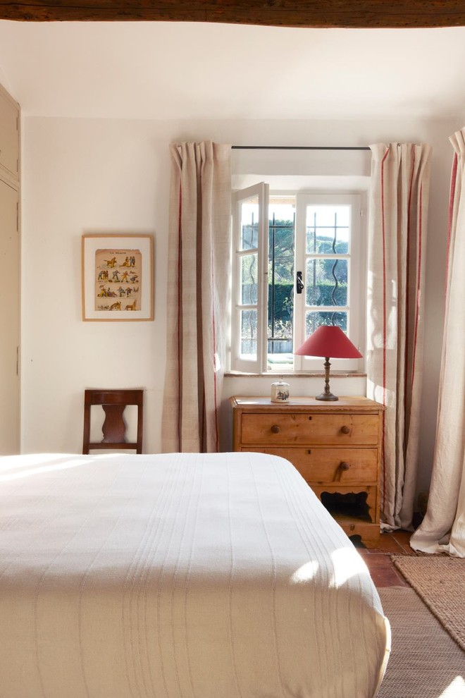 This is an example of a traditional bedroom in Marseille with white walls.