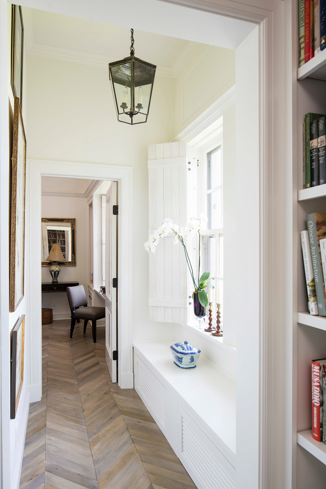 Traditional hallway in Minneapolis with white walls and light hardwood floors.