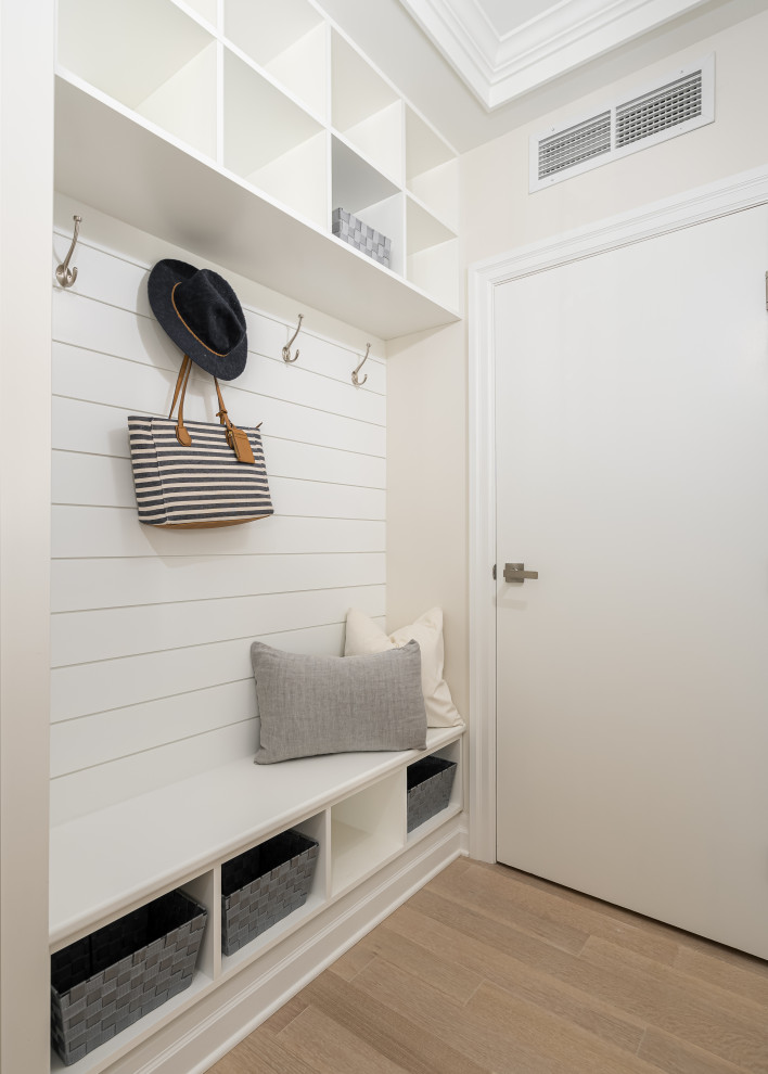 Small contemporary mudroom in Montreal with beige walls, light hardwood floors, a single front door, a white front door, brown floor and coffered.