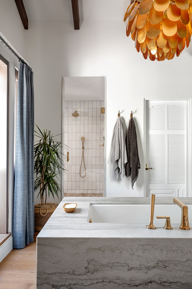 Cette photo montre une petite salle de bain principale méditerranéenne en bois clair avec une baignoire encastrée, une douche ouverte, un bidet, un carrelage blanc, des carreaux de céramique, un mur blanc, un sol en bois brun, un sol gris, une cabine de douche à porte battante, un banc de douche, meuble-lavabo encastré et poutres apparentes.