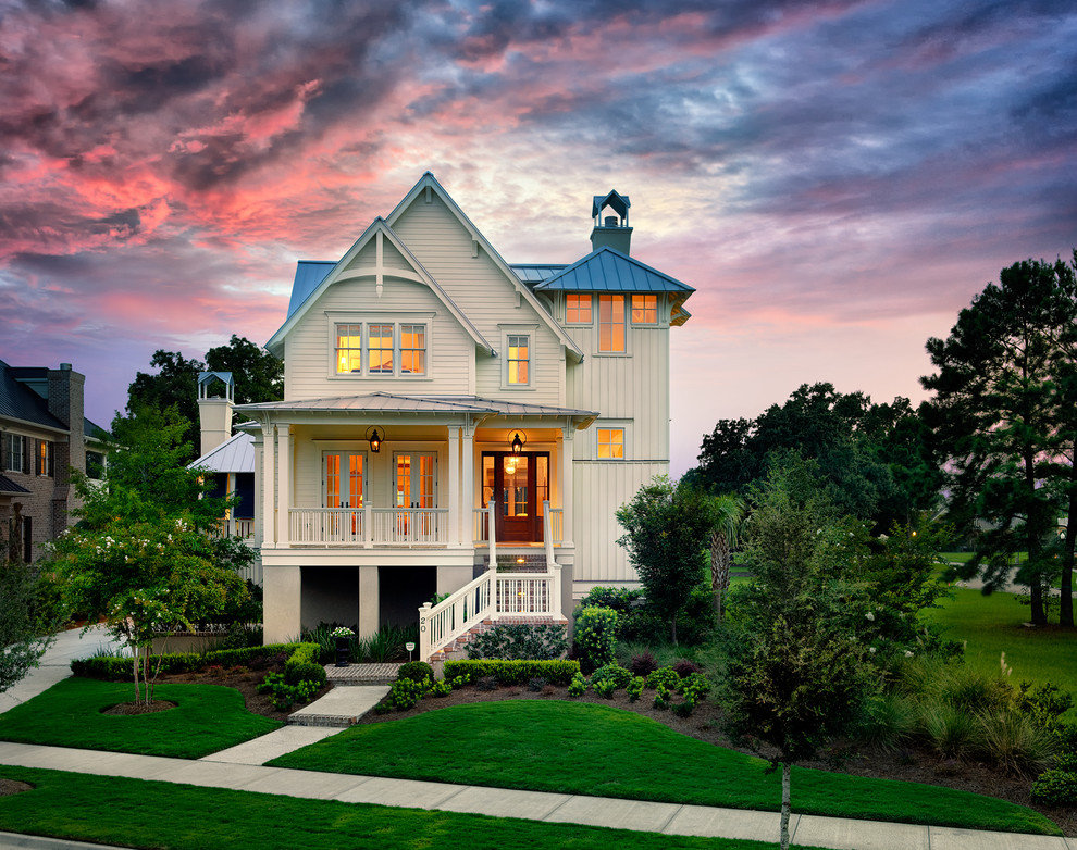 Design ideas for a mid-sized traditional two-storey white exterior in Charleston with wood siding.