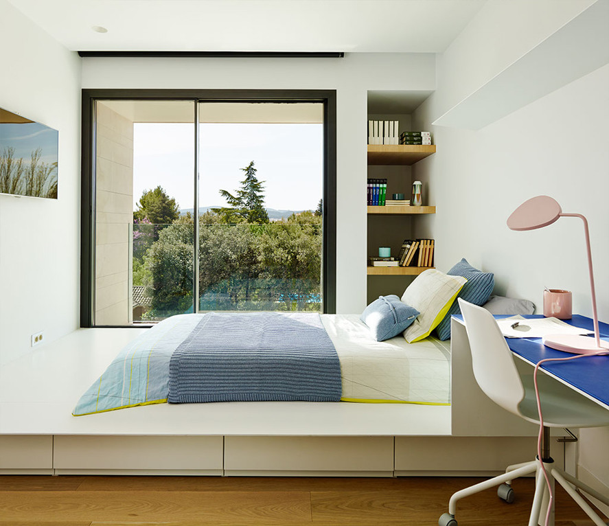 Mid-sized contemporary gender-neutral kids' room in Barcelona with white walls.