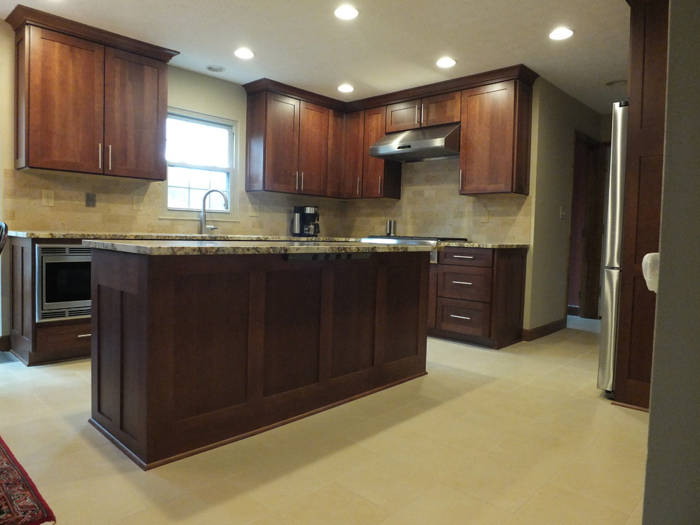 Example of a mid-sized transitional l-shaped ceramic tile eat-in kitchen design in Columbus with an undermount sink, shaker cabinets, brown cabinets, granite countertops, beige backsplash, ceramic backsplash, stainless steel appliances and an island