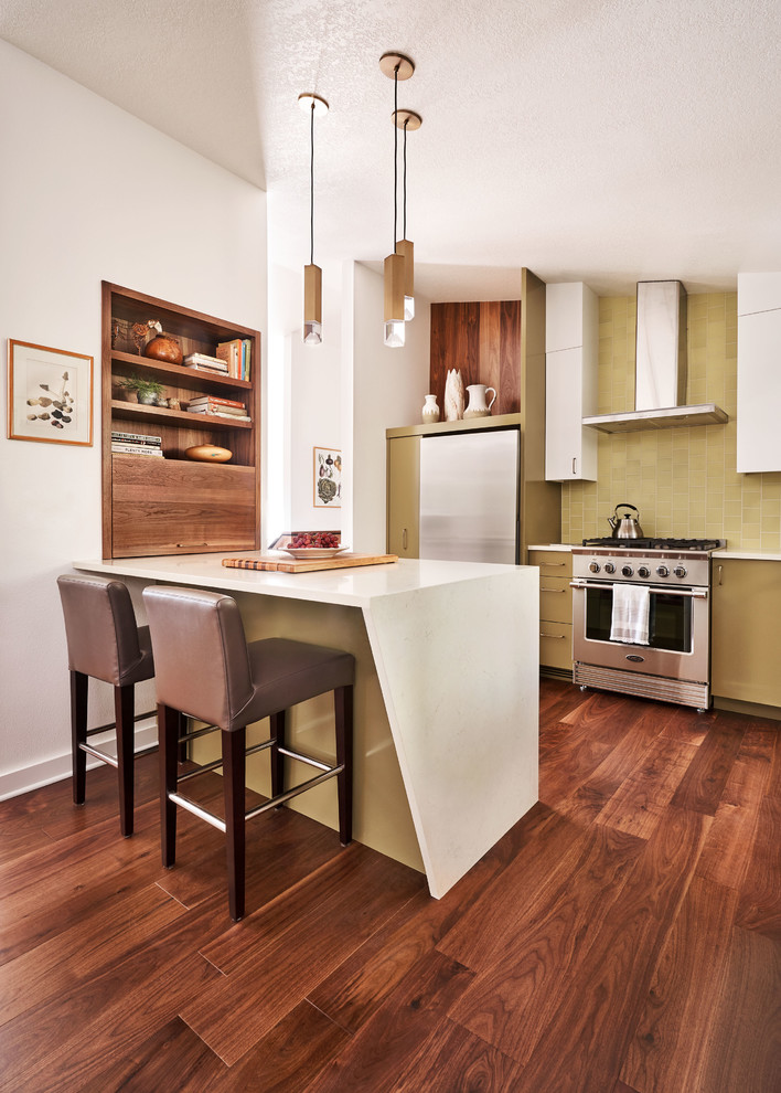 Photo of a mid-sized contemporary galley eat-in kitchen in Portland with an undermount sink, flat-panel cabinets, green cabinets, quartz benchtops, green splashback, porcelain splashback, stainless steel appliances, medium hardwood floors, a peninsula, brown floor and beige benchtop.