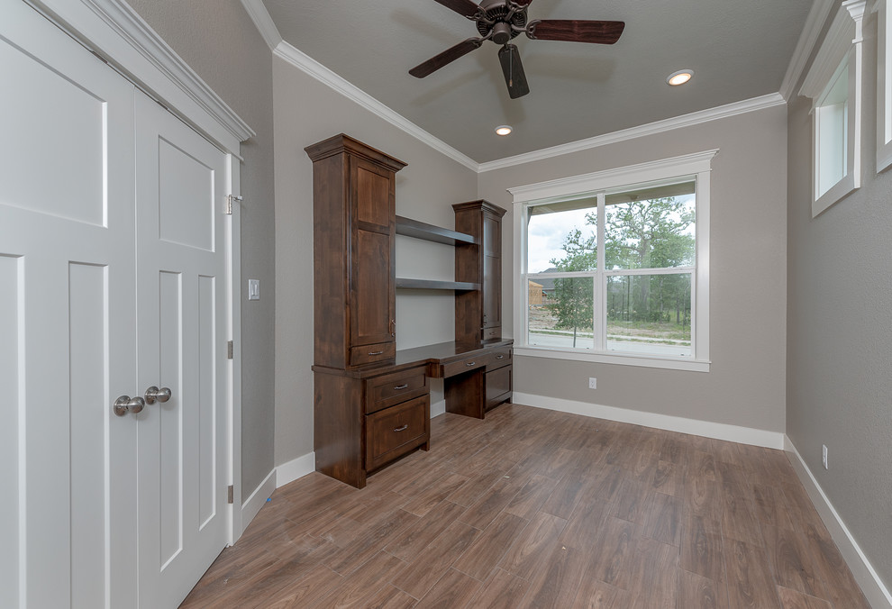 Mid-sized arts and crafts study room in Other with grey walls, ceramic floors, a built-in desk and brown floor.