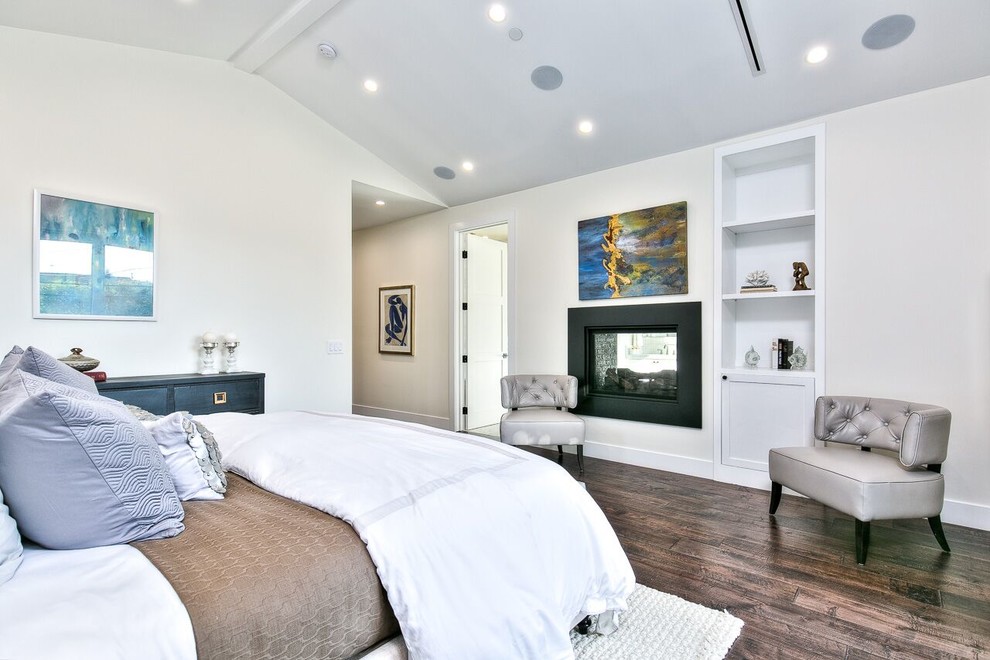 This is an example of a mid-sized transitional master bedroom in Orange County with brown walls, porcelain floors, a two-sided fireplace, a metal fireplace surround and brown floor.