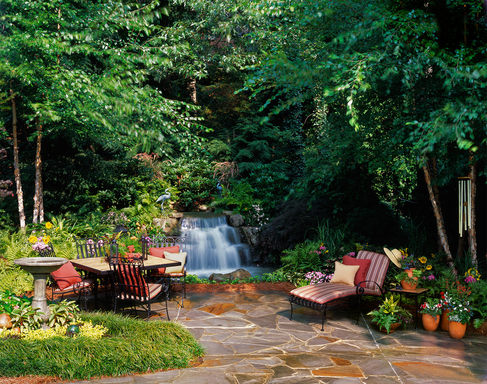 This is an example of a traditional patio in Atlanta with a water feature.