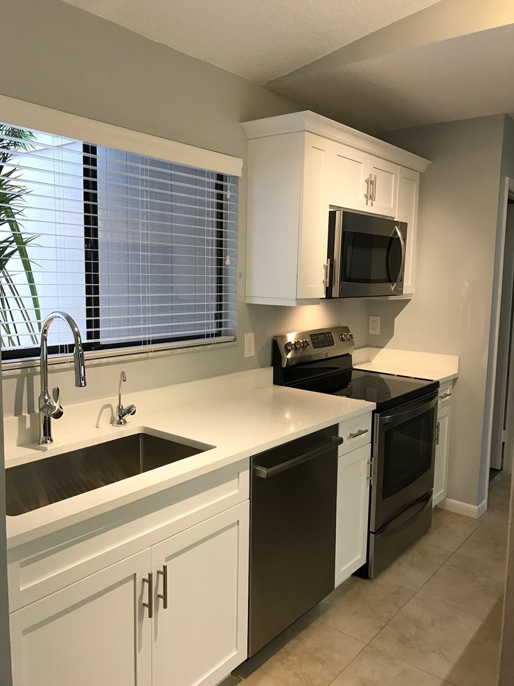 Example of a small transitional galley porcelain tile eat-in kitchen design in Miami with an undermount sink, shaker cabinets, white cabinets, quartzite countertops, white backsplash and stainless steel appliances