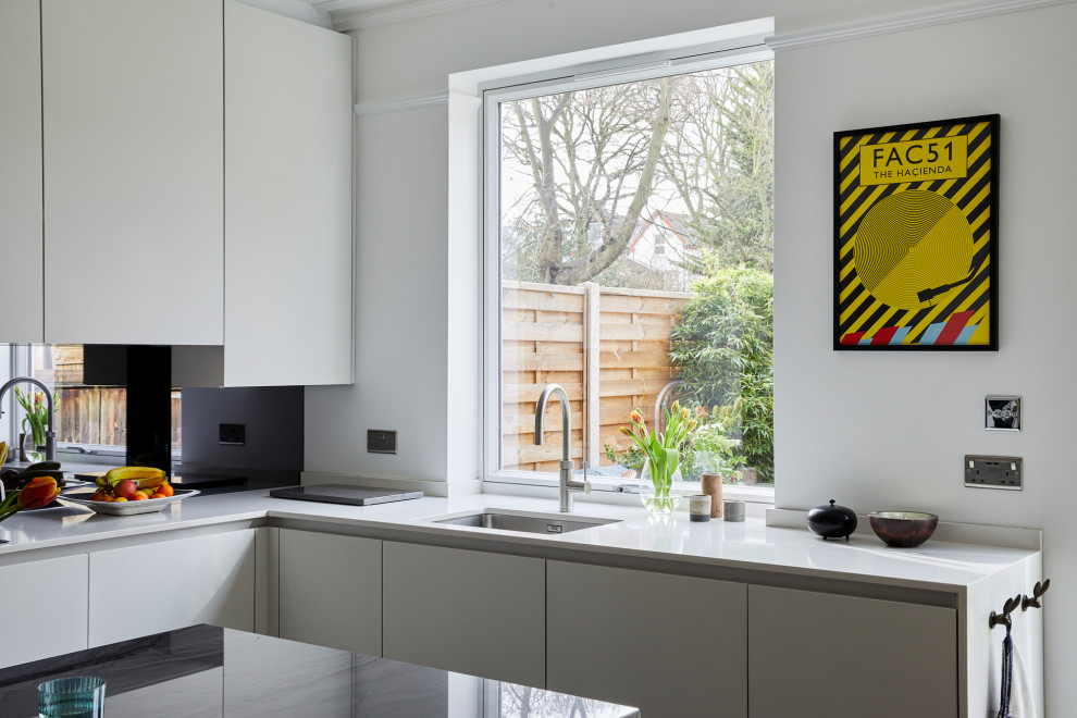 Foto di una cucina moderna di medie dimensioni con lavello sottopiano, ante lisce, ante bianche, top in quarzite, paraspruzzi con lastra di vetro, elettrodomestici neri, parquet scuro, pavimento marrone e top bianco