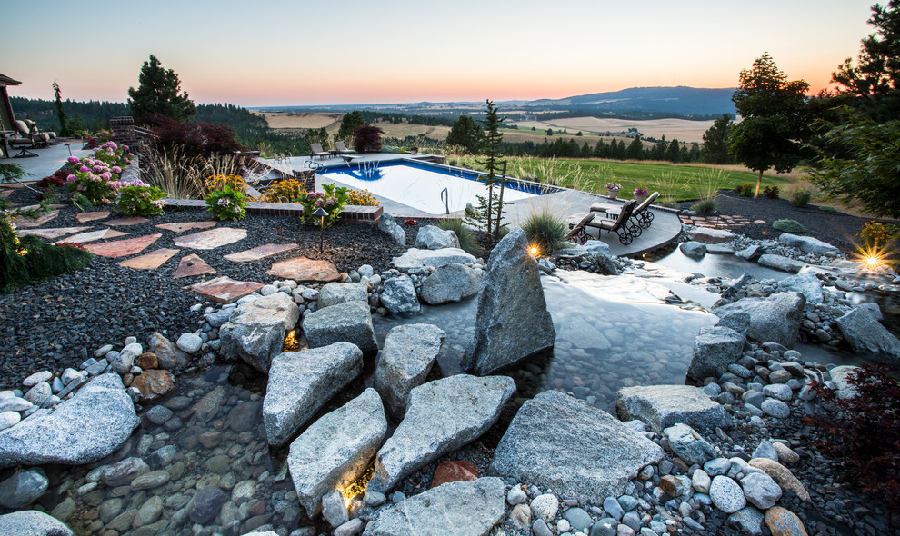 This is an example of a large traditional backyard garden in Seattle with a water feature and gravel.