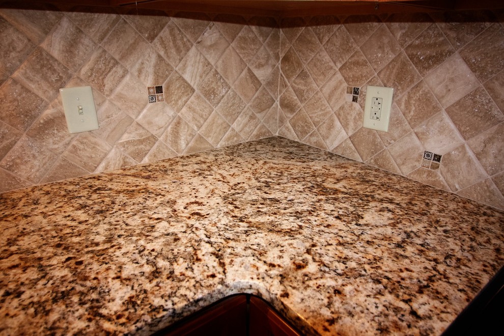Home design - large traditional l-shaped linoleum floor home design idea with an undermount sink, raised-panel cabinets, light wood cabinets, granite countertops, beige backsplash, porcelain backsplash and an island