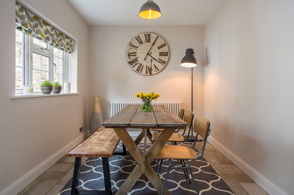 This is an example of a small country separate dining room in Other with grey walls and grey floor.