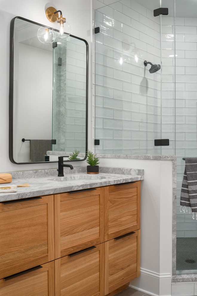 Inspiration for a mid-sized modern master bathroom in Nashville with recessed-panel cabinets, light wood cabinets, a freestanding tub, a corner shower, yellow tile, cement tile, white walls, porcelain floors, an undermount sink, marble benchtops, grey floor, a hinged shower door and grey benchtops.