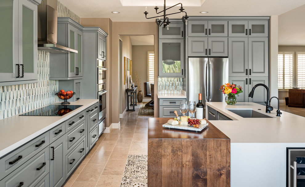 Design ideas for a mid-sized transitional kitchen in Phoenix with a single-bowl sink, grey cabinets, quartz benchtops, glass tile splashback, stainless steel appliances, limestone floors, with island, beige floor, white benchtop, raised-panel cabinets and multi-coloured splashback.