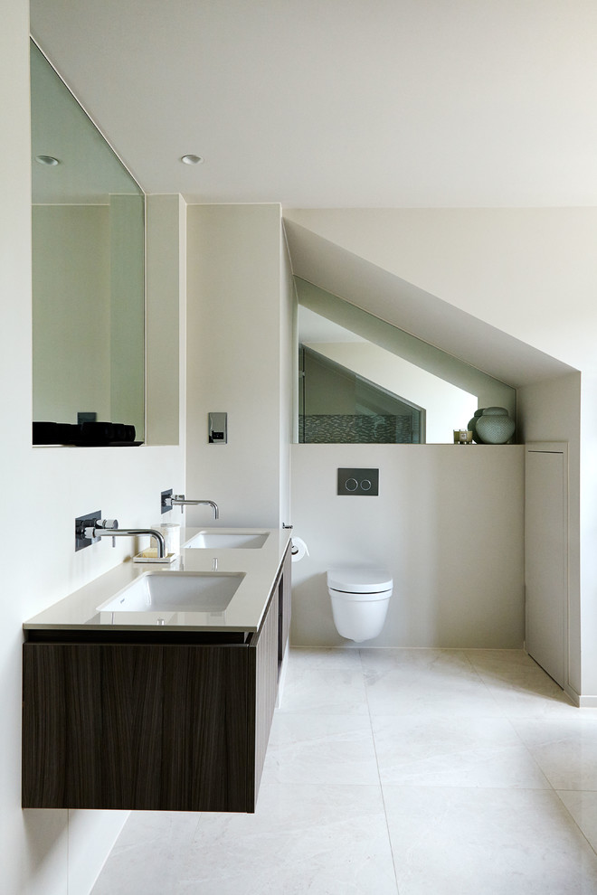 Photo of a contemporary bathroom in London with an undermount sink, flat-panel cabinets, dark wood cabinets, beige walls and a wall-mount toilet.