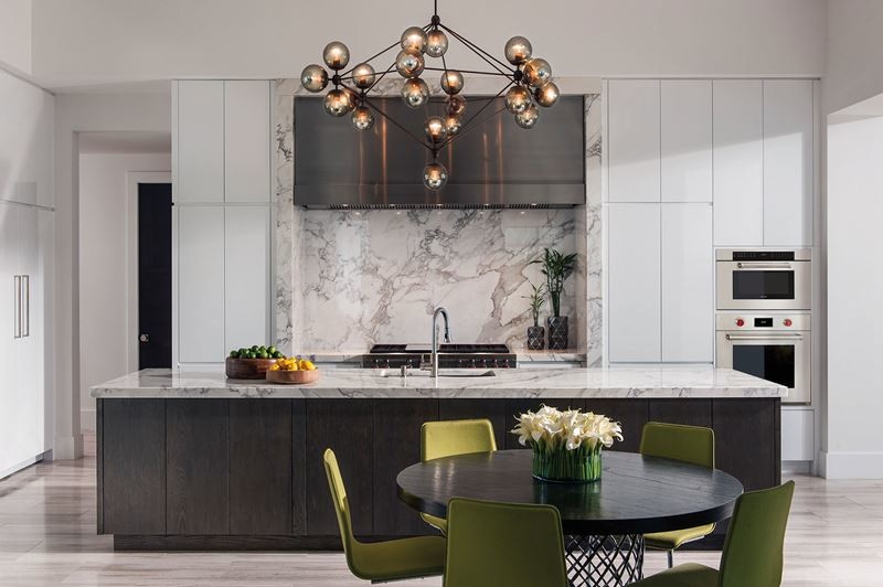 Example of a large transitional galley porcelain tile open concept kitchen design in Austin with a double-bowl sink, flat-panel cabinets, white cabinets, marble countertops, multicolored backsplash, stone slab backsplash, stainless steel appliances and an island