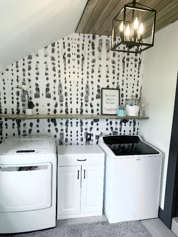 Expansive country single-wall laundry room in Columbus with grey walls, grey floor and wallpaper.