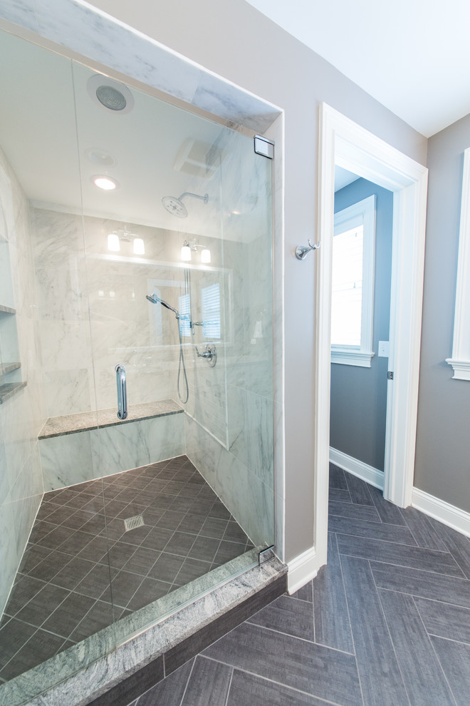 This is an example of a mid-sized transitional master bathroom in Chicago with an undermount sink, raised-panel cabinets, white cabinets, granite benchtops, an alcove shower, a two-piece toilet, gray tile, porcelain tile, grey walls, porcelain floors, grey floor, a hinged shower door, grey benchtops, a niche, a double vanity and a built-in vanity.