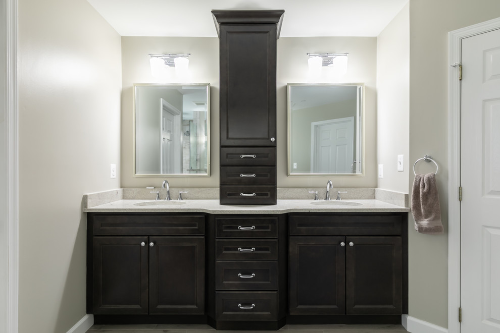 Photo of a large transitional master bathroom in DC Metro with recessed-panel cabinets, black cabinets, an open shower, a two-piece toilet, beige tile, porcelain tile, beige walls, porcelain floors, an undermount sink, granite benchtops, grey floor, an open shower and beige benchtops.