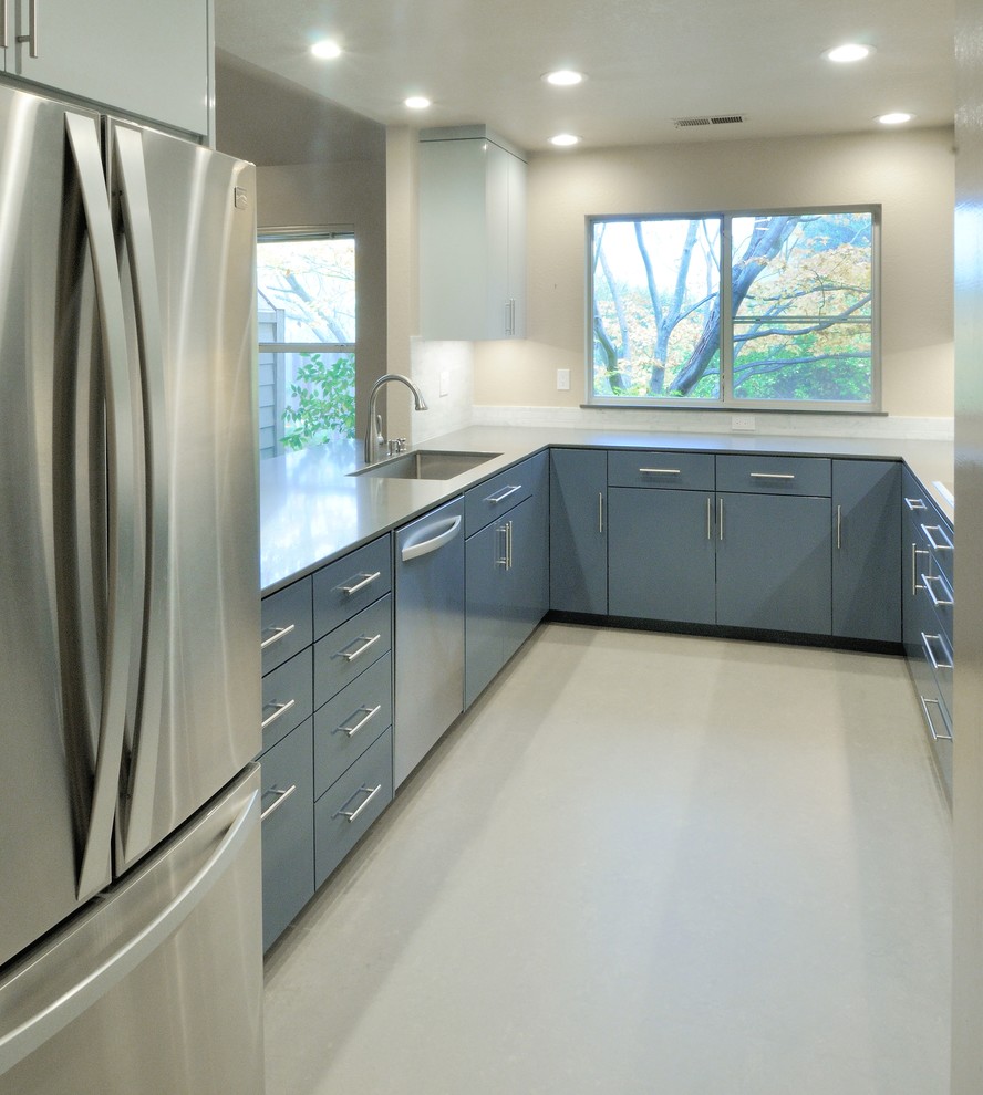 Photo of a mid-sized contemporary u-shaped separate kitchen in Sacramento with an undermount sink, flat-panel cabinets, blue cabinets, solid surface benchtops, grey splashback, stone tile splashback, stainless steel appliances, linoleum floors and no island.