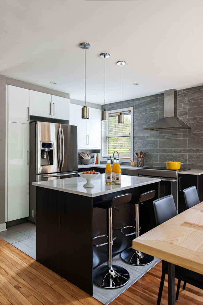 Contemporary kitchen in Montreal with stainless steel appliances and slate splashback.