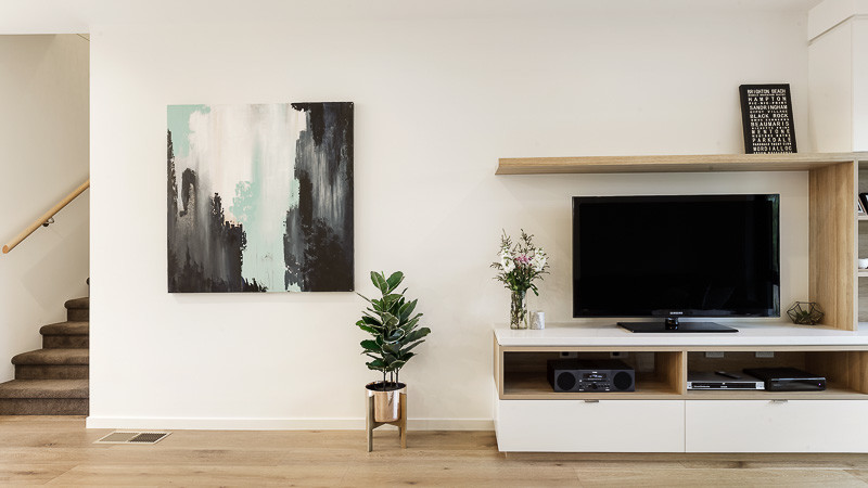This is an example of a scandinavian open concept living room in Melbourne with white walls, light hardwood floors, a freestanding tv and no fireplace.