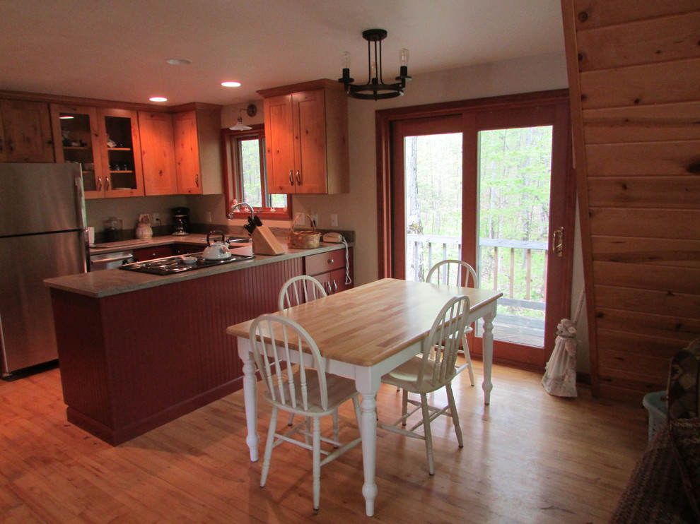 Kitchen - rustic u-shaped light wood floor kitchen idea with shaker cabinets, red cabinets, solid surface countertops, a peninsula and beige countertops