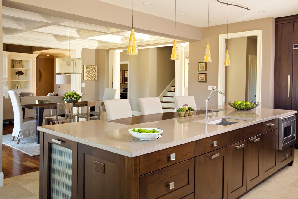 Transitional l-shaped travertine floor eat-in kitchen photo in Boston with furniture-like cabinets, dark wood cabinets, concrete countertops, beige backsplash, stone tile backsplash, paneled appliances, gray walls and an island