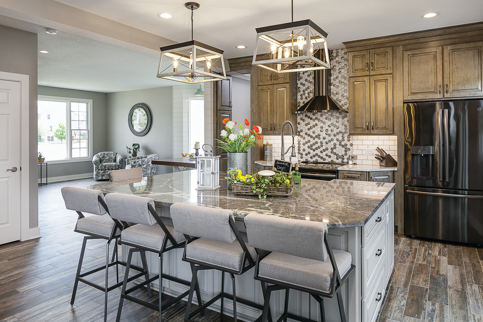 Mid-sized transitional single-wall cement tile floor and multicolored floor eat-in kitchen photo with a farmhouse sink, raised-panel cabinets, distressed cabinets, granite countertops, white backsplash, subway tile backsplash, black appliances, an island and gray countertops