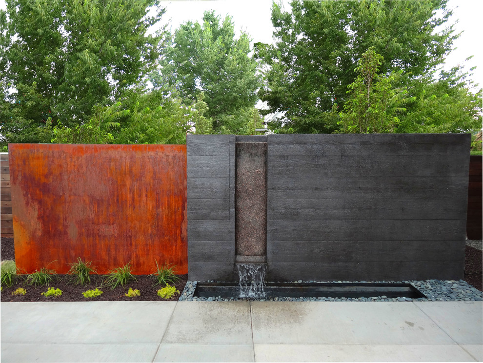 Photo of a modern garden in Denver with a water feature and concrete pavers.