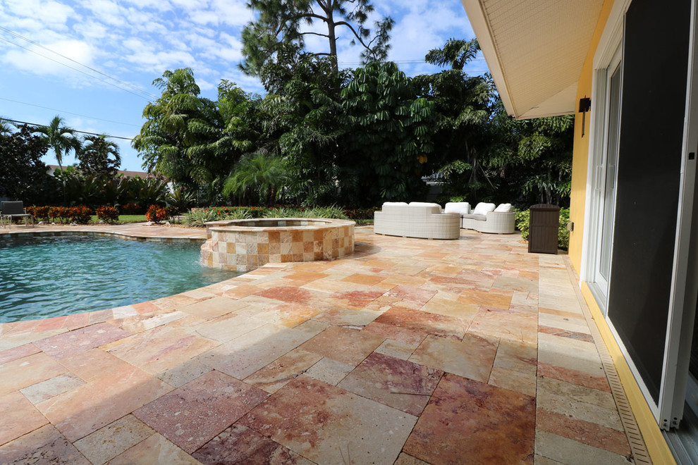 Large transitional backyard tile and custom-shaped hot tub photo in Miami
