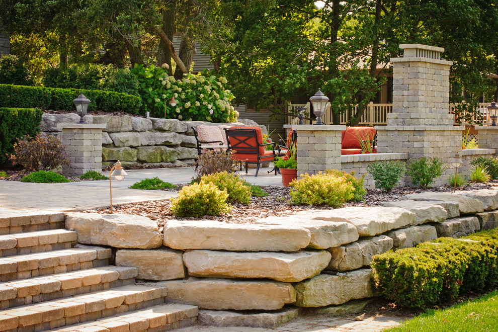 This is an example of a large backyard full sun garden in Other with a retaining wall and brick pavers.