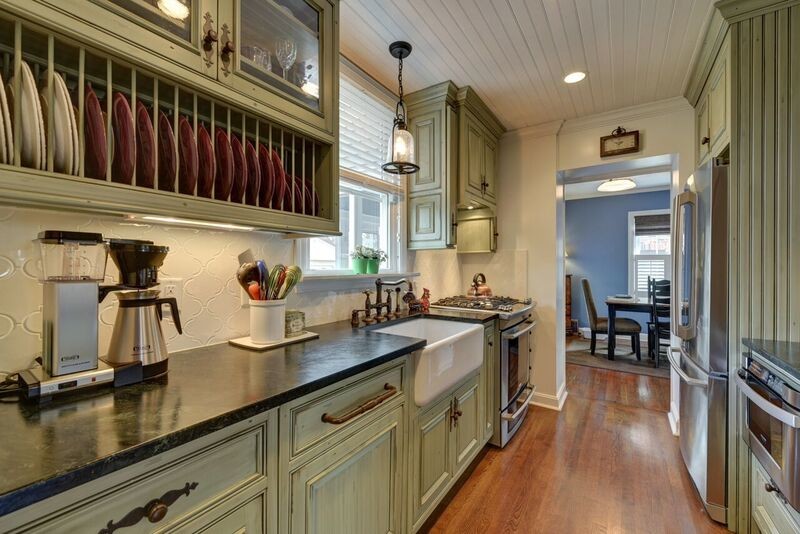 Small traditional galley separate kitchen in Cleveland with a farmhouse sink, beaded inset cabinets, green cabinets, soapstone benchtops, white splashback, ceramic splashback, stainless steel appliances, medium hardwood floors and no island.