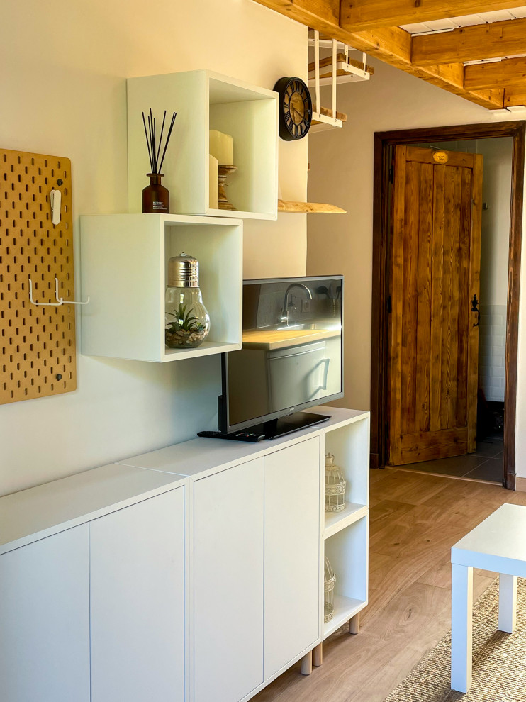 Inspiration för små moderna loftrum, med beige väggar, laminatgolv och en väggmonterad TV