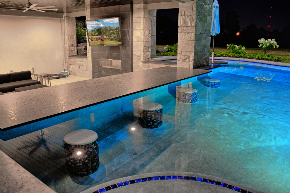 Imagen de piscina infinita extra grande a medida en patio trasero con paisajismo de piscina y suelo de baldosas