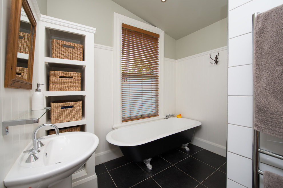 Inspiration for a traditional bathroom in Christchurch with a claw-foot tub, an alcove shower, black tile, ceramic tile, white walls, ceramic floors and a pedestal sink.