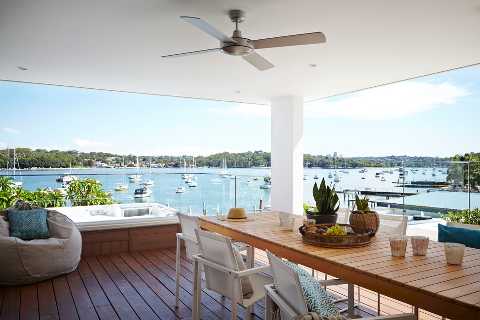 Contemporary backyard deck in Sydney with a roof extension.