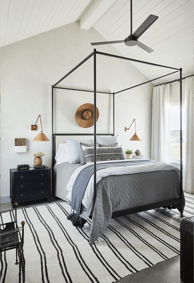 Photo of a beach style bedroom in Dallas with white walls, concrete floors and grey floor.
