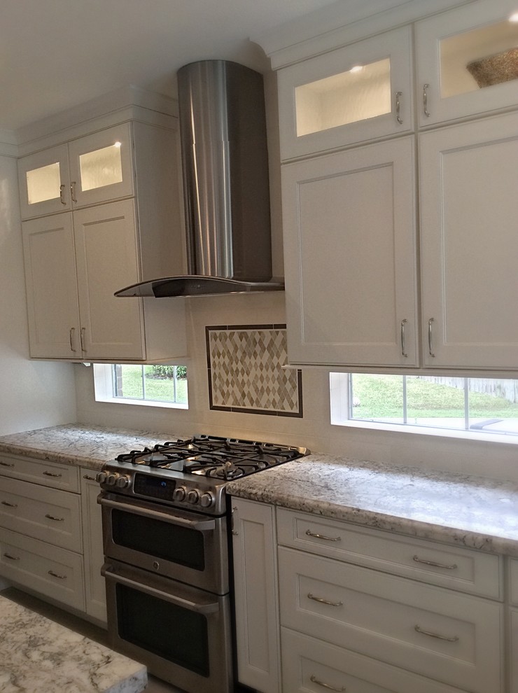 Inspiration for a mid-sized transitional u-shaped ceramic tile eat-in kitchen remodel in Houston with a farmhouse sink, recessed-panel cabinets, white cabinets, granite countertops, white backsplash, stone tile backsplash, stainless steel appliances and an island