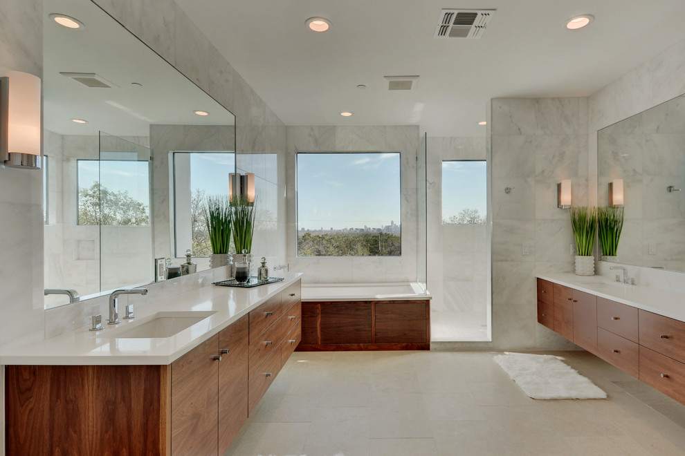 Contemporary master bathroom in Austin with an undermount sink, flat-panel cabinets, medium wood cabinets, a drop-in tub, a corner shower and gray tile.