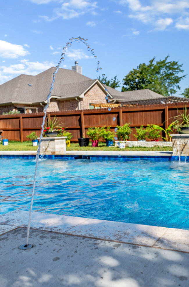 This is an example of a large modern backyard rectangular pool with decking.