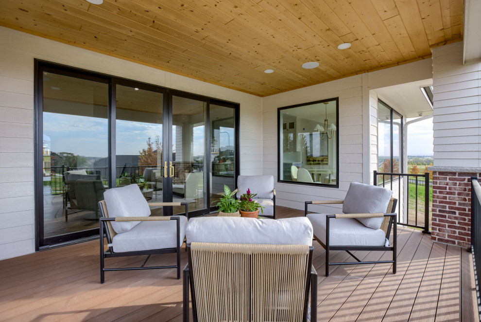 Deck - backyard metal railing deck idea in Omaha with a roof extension