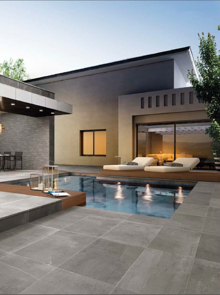 This is an example of a mid-sized modern custom-shaped pool in Miami with tile.