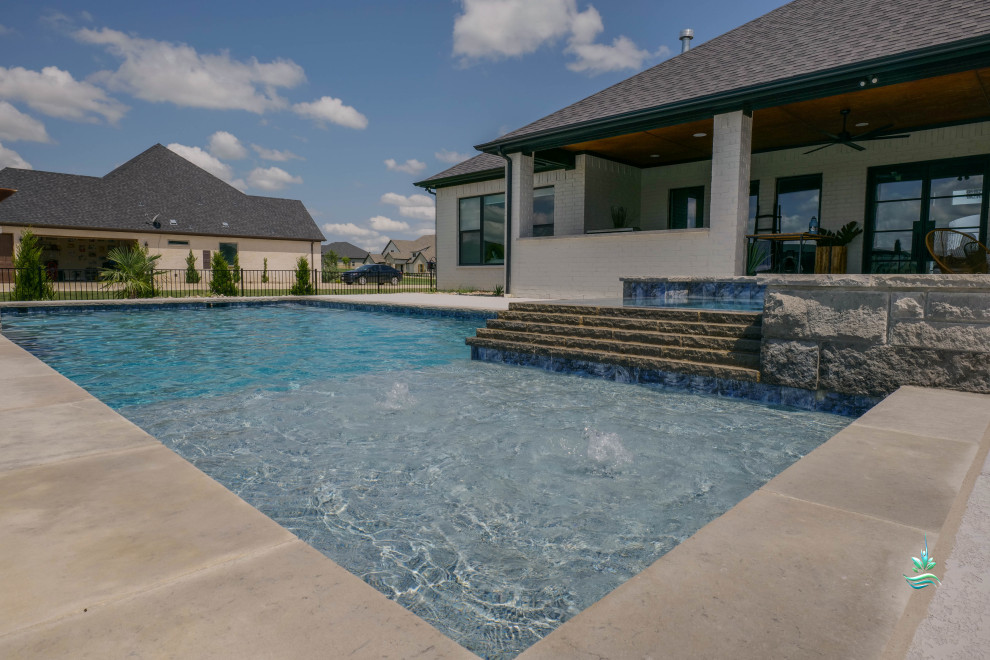 Diseño de piscina natural retro extra grande rectangular en patio trasero con privacidad y entablado