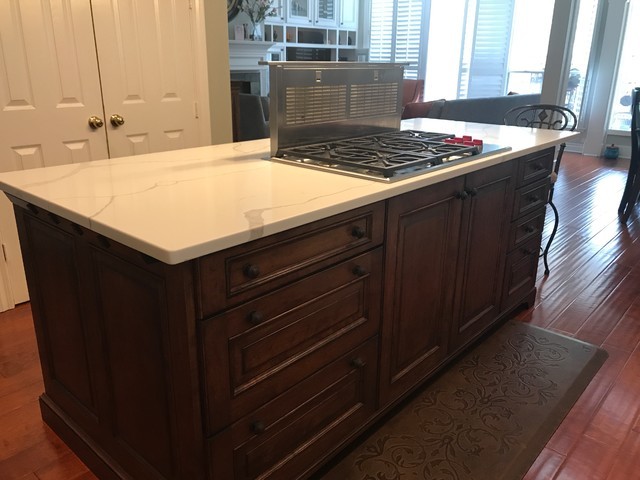 Inspiration for a traditional kitchen in Houston with raised-panel cabinets, dark wood cabinets, quartz benchtops, stainless steel appliances, laminate floors, with island and brown floor.