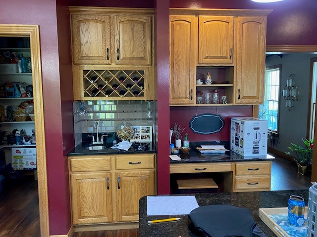 Large transitional l-shaped laminate floor and brown floor open concept kitchen photo with an undermount sink, flat-panel cabinets, white cabinets, quartz countertops, white backsplash, ceramic backsplash, stainless steel appliances, an island and white countertops
