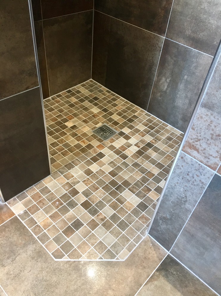 Photo of a mid-sized country kids bathroom in Other with a drop-in tub, an open shower, brown tile, a pedestal sink, tile benchtops, a one-piece toilet, porcelain floors and brown floor.