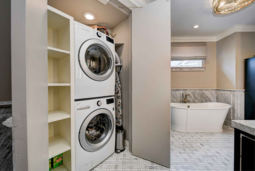 インディアナポリスにある高級なエクレクティックスタイルのおしゃれな家事室 (上下配置の洗濯機・乾燥機、ベージュの壁、磁器タイルの床、パネル壁、大理石カウンター) の写真