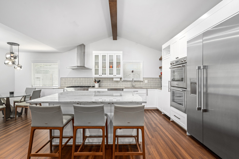 Foto på ett mellanstort 60 tals grå kök, med skåp i shakerstil, vita skåp, bänkskiva i kvartsit, bambugolv, en köksö och brunt golv