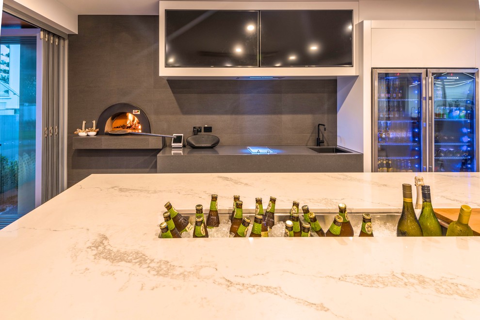 Inspiration for a large contemporary galley wet bar in Sunshine Coast with an undermount sink, white cabinets, quartz benchtops, grey splashback, ceramic splashback, ceramic floors, grey floor and white benchtop.